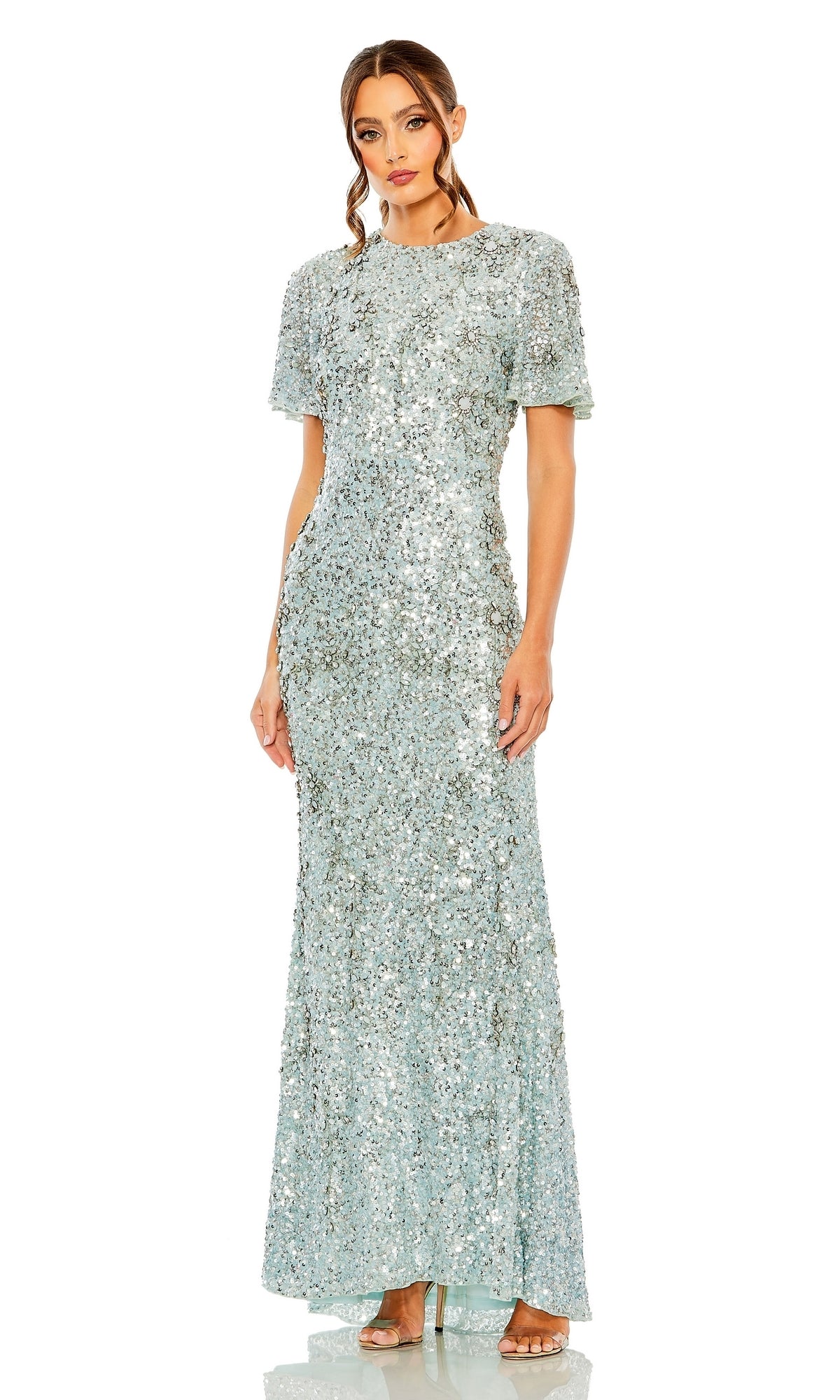 A woman stands against a white background wearing the Mac Duggal Long Formal Dress 93932, a floor-length, short-sleeved, beaded gown with a fitted silhouette and nude heels.